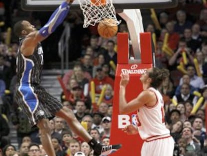 Dwight Howard machaca el aro ante la mirada de Luol Deng, en el suelo, y Joakim Noah.