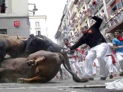 An El Tajo y La Reina ranch fighting bull falls to the ground as it takes the Mercaderes curve during the second running of the bulls of the San Fermin festival in Pamplona, northern Spain, July 8, 2015. One runner was gored in the run that lasted 2 minutes and 14 seconds, according to local media. REUTERS/Susana Vera      TPX IMAGES OF THE DAY     