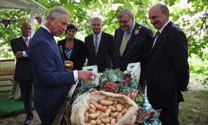 El príncipe de Gales mira lvarios productos de su marca en el 21º aniversario de Duchy Originals, en sepriembre de 2013.