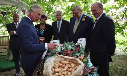 El príncipe de Gales mira lvarios productos de su marca en el 21º aniversario de Duchy Originals, en sepriembre de 2013.