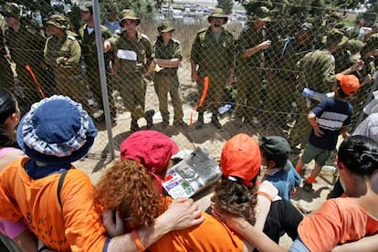 Agentes de seguridad israelíes vigilan a manifestantes contrarios a la retirada de Gaza, ayer en Kafar Maimon.