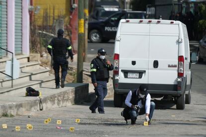 Police officers work at a crime scene where gunmen killed at least 13 Mexican police officers in an ambush in Coatepec Harinas, March 2021.