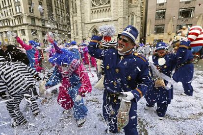 Ciudadanos disfrazados lanzan confeti durante el desfile.