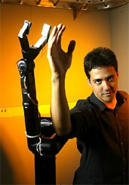 El neurobiólogo español José Carmena posa junto al brazo robótico.