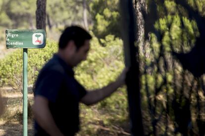 Un agente forestal cierra la cancela del Centro de visitantes El Acebuche.