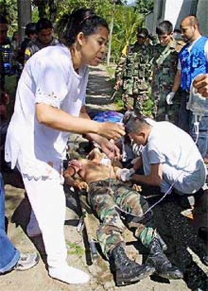 Unos enfermeros atienden a un soldado herido ayer en la Comuna 13.