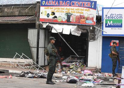 Un oficial de la policía de Sri Lanka hace guardia frente una tienda destruida tras un ataque en Minuwangoda.