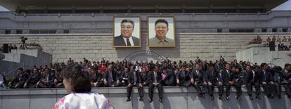 15 de abril del 2012. Norcoreanos sentados delante de los retratos de los líderes , Kim Il Sung, izquierda, y Kim Jong Il, al final de un desfile militar masiva en Pyongyang Kim Il Sung la plaza para celebrar los 100 años del nacimiento de Kim Il Sung.