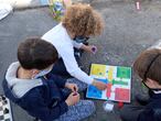 MADRID, 25/03/2021.-Tres niños juegan sobre el asfalto de la calle junto al colegio Asuncion Rincón este jueves en Madrid. Familias asociadas a 15 colegios de la ciudad de Madrid vuelven a cortar calles para reivindicar espacios escolares seguros, libres de ruidos y sin contaminación en el marco de la iniciativa Revuelta Escolar.-EFE/Ana Márquez