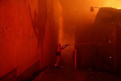 Un bombero intenta apagar las llamas que se extienden por las calles de Paradise, en el Estado de California.