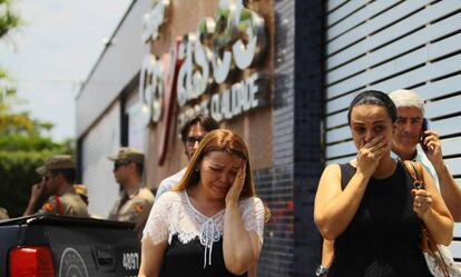 Pais de alunos diante do Col&eacute;gio Goyases, ao fundo, policiais militares. 