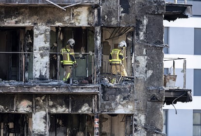 Bomberos trabajan en el edificio que fue devastado por las llamas, el sábado.