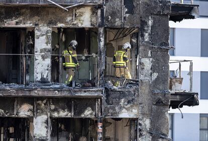 Bomberos trabajan en el edificio que fue devastado por las llamas, el sábado.