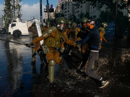 Un manifestante es detenido por la policía durante una protesta del tercer aniversario del estallido social chileno