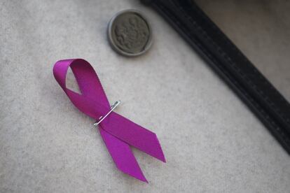 Una mujer porta un lazo contra la violencia de género durante el minuto de silencio en la plaza de Sant Jaume de Barcelona.
