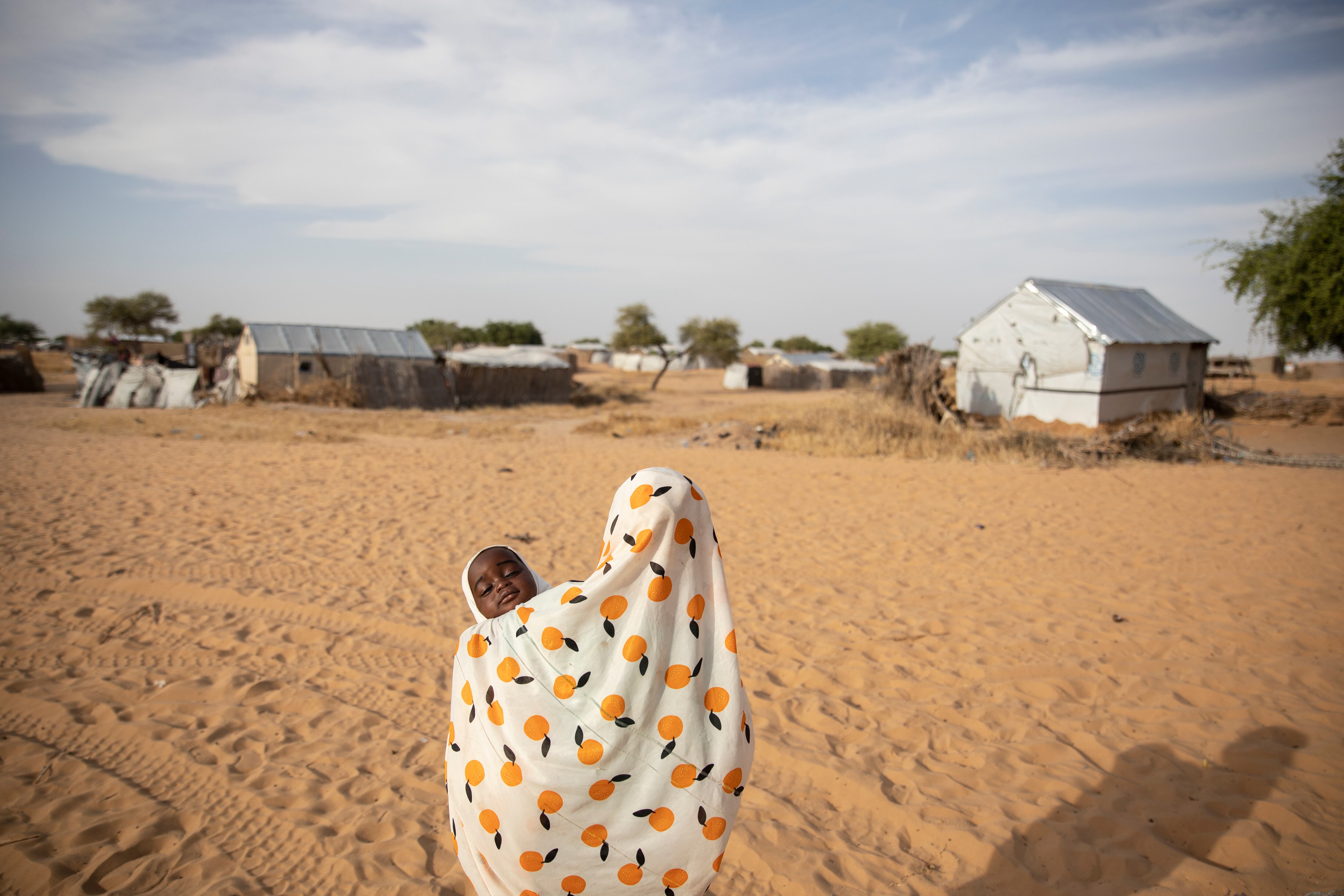 Roukaya, de 11 años, pasea con su hermana Maimouna de nueve meses, cerca de su casa. Ambas hermanas presentan carencias alimentarias que comprometerán su futuro desarrollo físico y cognitivo. 