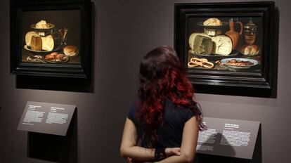Una mujer observa dos bodegones de la pintora flamenca Clara Peeters, en una exposición en el Museo del Prado.