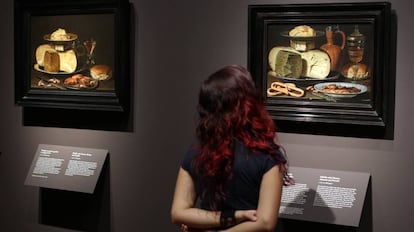 Una mujer observa dos bodegones de la pintora flamenca Clara Peeters, en una exposición en el Museo del Prado.