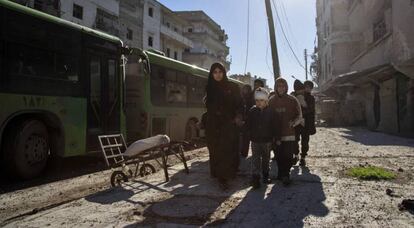 Una familia siria se dirige al punto de encuentro para la evacuación de Alepo.