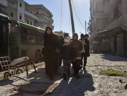 Una familia siria se dirige al punto de encuentro para la evacuación de Alepo.