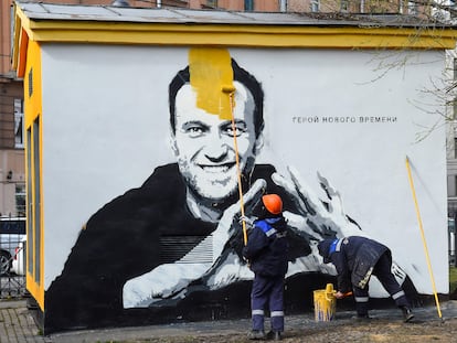 Unos trabajadores de la limpieza borran un grafiti con la imagen del opositor Alexéi Navalni en San Petersburgo.