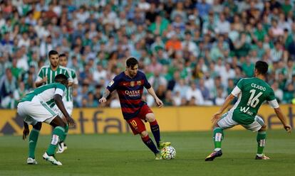 Leo Messi controla el balón ante dos jugadores del Real Betis.