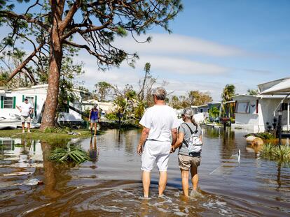 People walk through a neighborhood in Fort Myers (Florida) flooded by the passage of Hurricane 'Ian.'