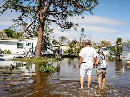 Este jueves 29 de septiembre, personas caminan por un vecindario en Fort Myers (Florida), inundado traes el paso del huracán 'Ian'.