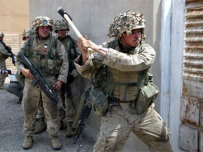 Un <i>marine</i> del Primer Batallón del 5º Regimiento derriba la puerta de una casa de Faluya en busca de armamento.