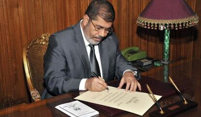Mohamed Morsi firma el decreto de aprobación de la nueva Constitución, el martes en El Cairo.