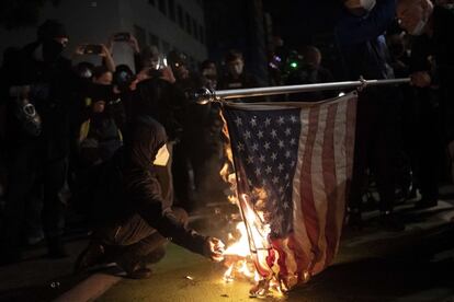 Un joven quema una bandera durante una protesta en Portland, Oregon. 