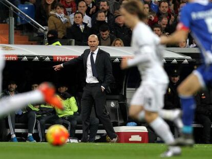 Zidane da indicaciones mientras Modric conduce el bal&oacute;n.