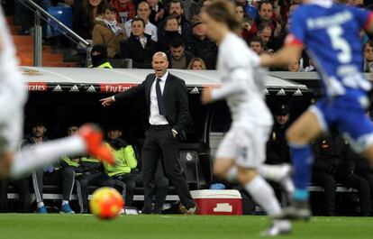 Zidane da indicaciones mientras Modric conduce el bal&oacute;n.