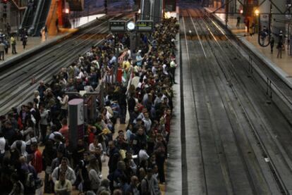 Viajeros esperan en los andenes de la estación de Cercanías de Atocha.