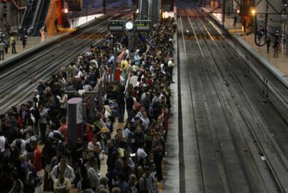 Viajeros esperan en los andenes de la estación de Cercanías de Atocha.