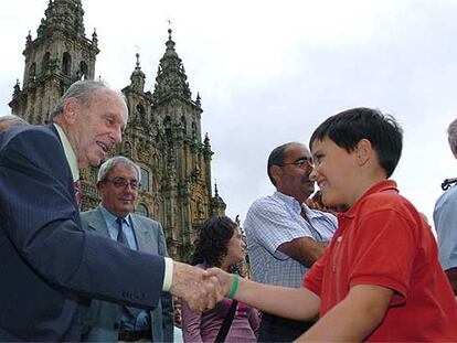 Manuel Fraga saluda a un niño en la plaza del Obradoiro, en Santiago de Compostela.