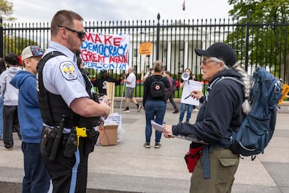 Un agente de la Policía de Parques de Estados Unidos habla con un activista mientras varios activistas protestan contra la deportación de Kilmar Abrego García y contra el presidente de EE. UU., Donald J. Trump, frente a la Casa Blanca, en abril de 2025