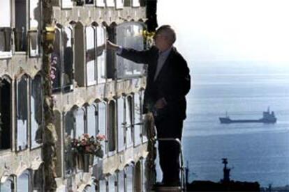 Un hombre depositando flores en un nicho del cementerio de Montjüic de Barcelona, ayer.