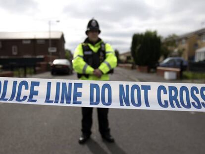 Un agente brit&aacute;nico vigilia la entrada de una calle de M&aacute;nchester durante una operaci&oacute;n policial vinculada con el atentado del 22-M el pasado domingo. 
 