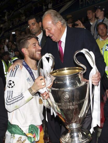 El rey Juan Carlos posa con el trofeo junto con el jugador del Real Madrid Sergio Ramos tras conseguir la victoria en el partido de la final de la Liga de Campeones disputado en Lisboa (fotograf&iacute;a facilitada por Casa Real).