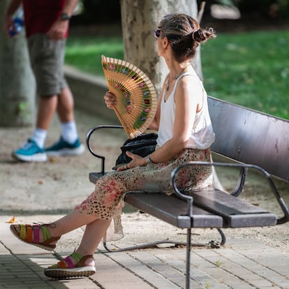 MADRID, SPAIN - 2025/06/23: A woman is seen fanning herself while sitting on a park bench during a day of high temperatures resulting from a heatwave. (Photo by Marcos del Mazo/LightRocket via Getty Images)