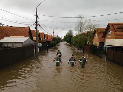 Rescatistas caminan por una calle inundada tras el desborde del río Claro, en Talca, Chile.