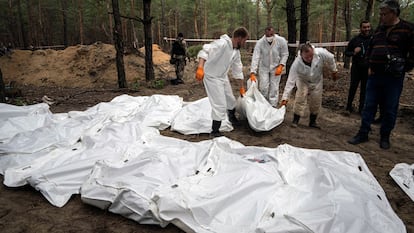 Técnicos forenses sacaban un cadáver de una fosa en Izium, el 18 de septiembre de 2022. Las autoridades calculaban que en el pinar de esta localidad, en el este de Ucrania, había enterradas más de 400 personas, muertas durante los seis meses de ocupación rusa.