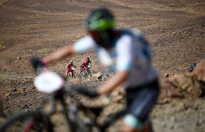 Los competidores llevan sus bicis durante la sexta etapa de Titan Desert 2018 entre Merzouga y Maadid, el 4 de mayo de 2018.