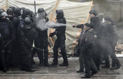 Manifestantes se enfrentan a policías antidisturbios durante una protesta frente al edificio del Parlamento en Kiev (Ucrania). El Parlamento ucraniano vota hoy una controvertida ley para la recuperación de las regiones separatistas de Donetsk y Lugansk, a las que declara 'territorios temporalmente ocupados' y señalar a Rusia como 'Estado agresor'.