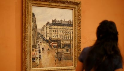 Una visitante observa el cuadro 'Rue Saint-Honoré por la tarde. Efecto de lluvia', de Camille Pissarro, en el Museo Thyssen-Bornemisza, en septiembre de 2019.