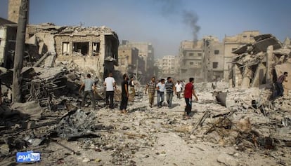 Varios hombres caminan por los escombros en el centro de Ariha (provincia de Idlib), tras estrellarse un caza del régimen el 3 de agosto.