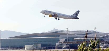 Avión sobrevolando la terminal T1 del aeropuerto de El Prat en Barcelona.