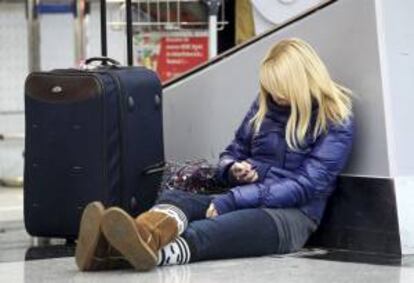 Una joven juega con su móvil mientras espera la salida de su vuelo en el aeropuerto de Duesseldorf (Alemania). EFE/Archivo