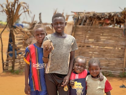 Mazim (en el centro), de 12 años, junto a tres de sus cinco hermanos menores, el 18 de julio en Adré (Chad). Mazim es de El Geneina, la capital de Darfur Occidental, ciudad donde la organización Human Rights Watch ha documentado una campaña de limpieza étnica por parte de las paramilitares Fuerzas de Apoyo Rápido y milicias aliadas. Como otros cientos de miles de niños, huyó de Sudán a Chad con su familia, tras el estallido de la guerra en abril de 2023. Desde hace más de un año, vive en el campo de refugiados de Adré. Mazim es zapatero a tiempo parcial. "Voy al mercado varias veces a la semana para lustrar zapatos y reparar otros mientras aprendo a coser. La comida que dan las organizaciones humanitarias no es suficiente, así que compro un poco de verduras e incluso carne, ya que estas no las proporciona la ayuda", comenta. En el futuro, le gustaría ser médico para "ayudar y curar a la gente".